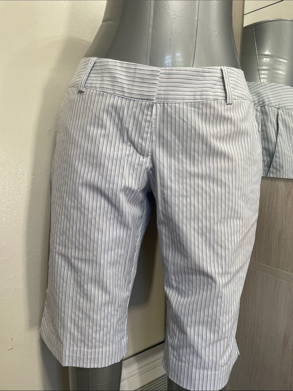 White Adidas shorts with gray blue and tan pin stripes.